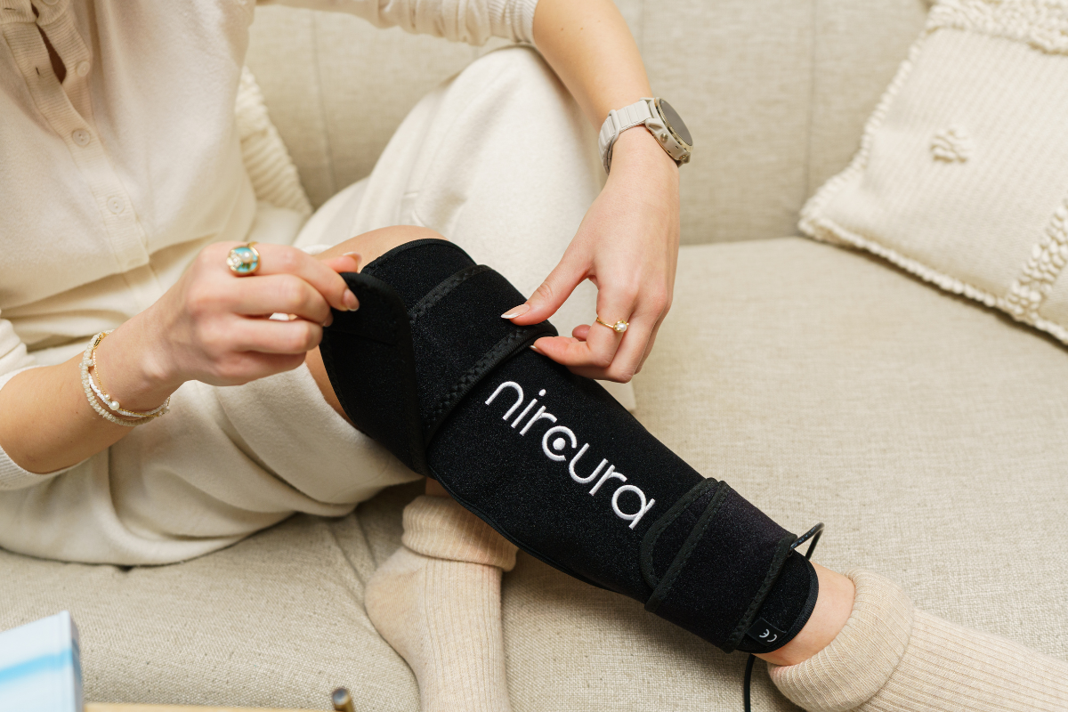 femeie folosind centura cu lumina rosie Nircura Light Belt Pro pentru dureri musculare